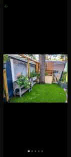 Wohnwagen mit Vorzelt und Holzhaus auf einen Campingplatz