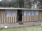 Sonniger Campingplatz mit Wohnwagen und Vorzelt.